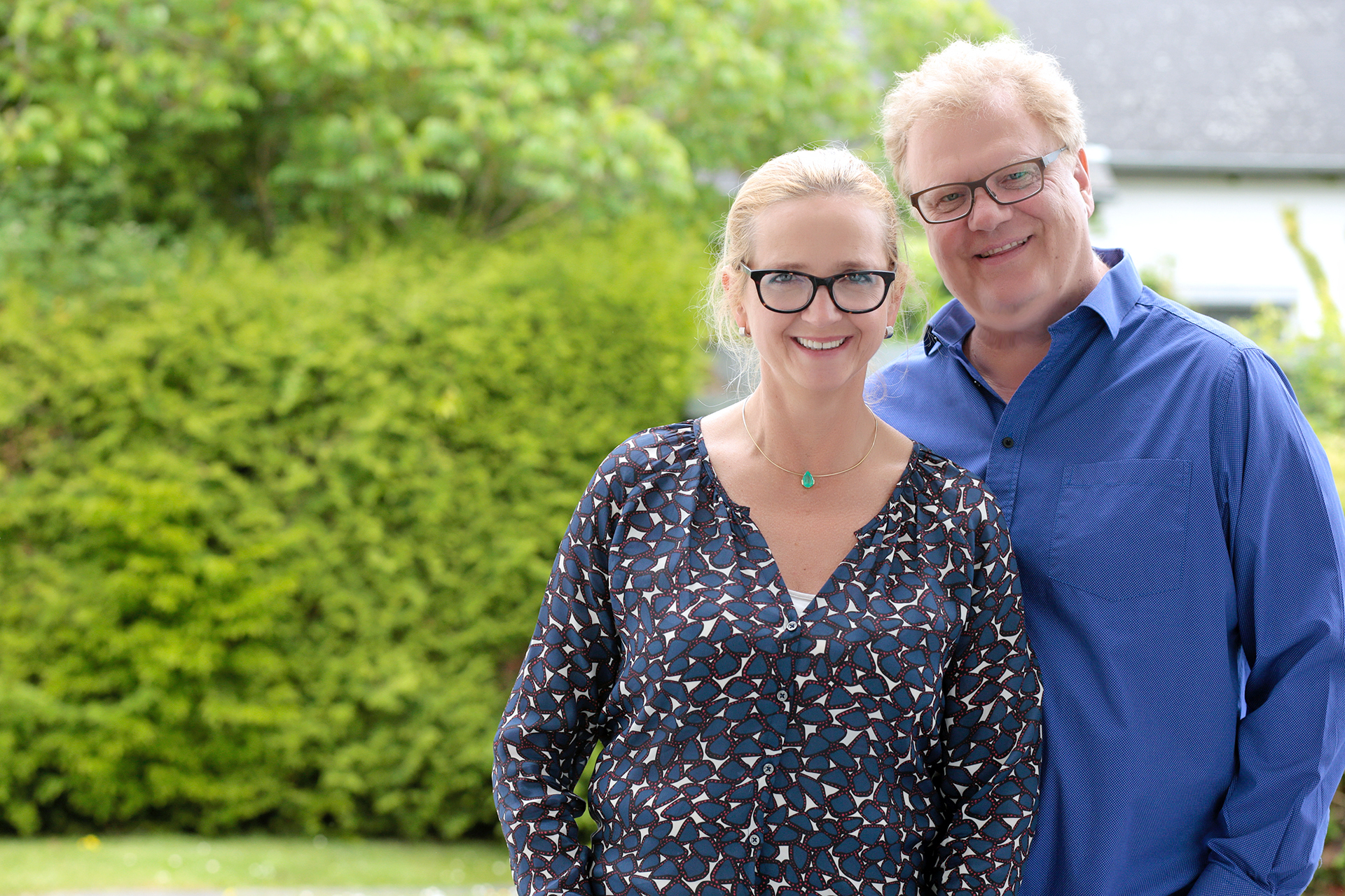 Zwei Zahnärzte der Praxis Thiele & Menk in Weilburg stehen lächelnd im Garten, repräsentierend die persönliche und moderne Zahnmedizin der Praxis.