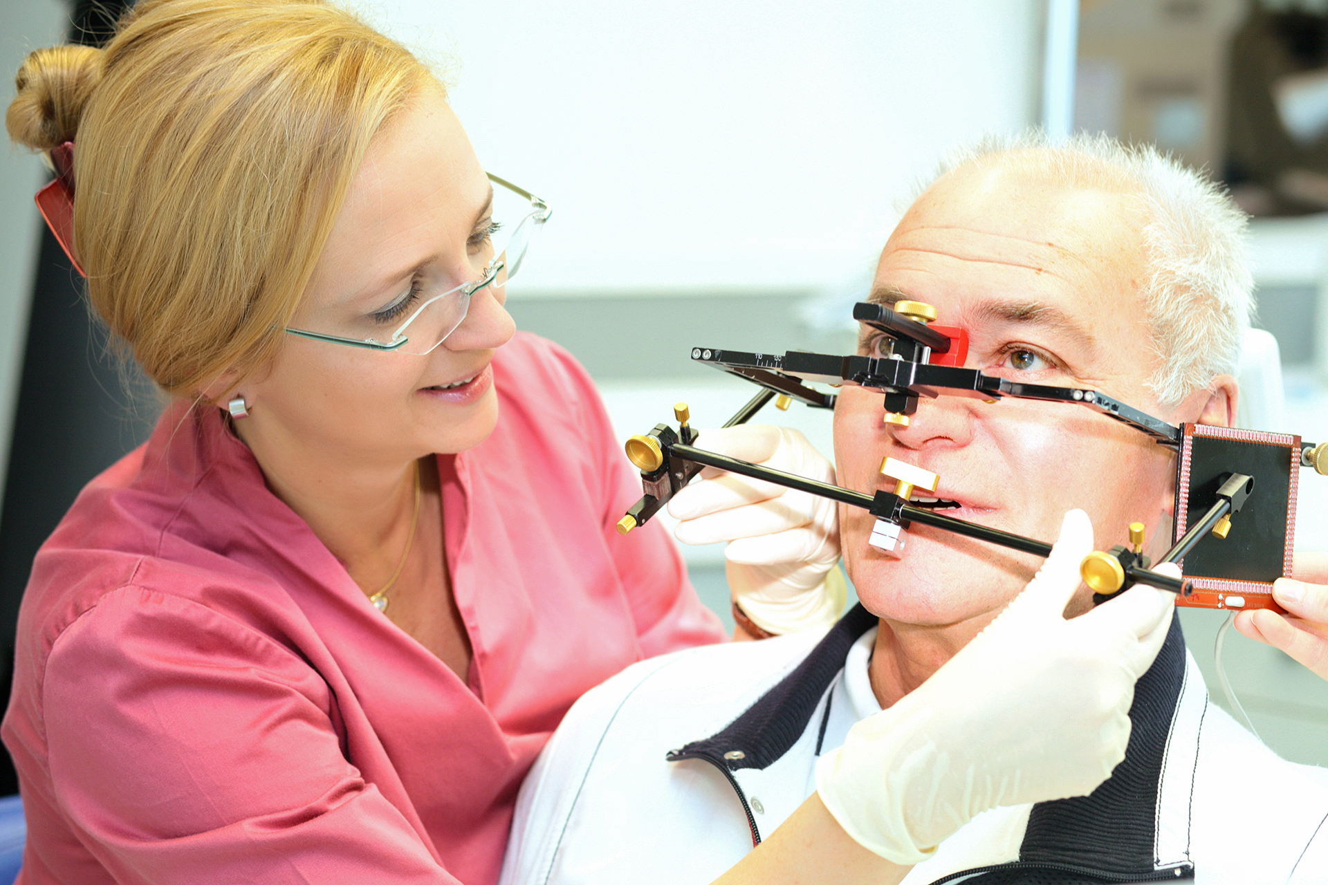 Eine Zahnärztin der modernen Zahnarztpraxis Thiele & Menk in Weilburg verwendet ein diagnostisches Gerät zur Untersuchung eines Patienten, was die Praxis’ Fokus auf moderne, patientenorientierte Zahnmedizin widerspiegelt.