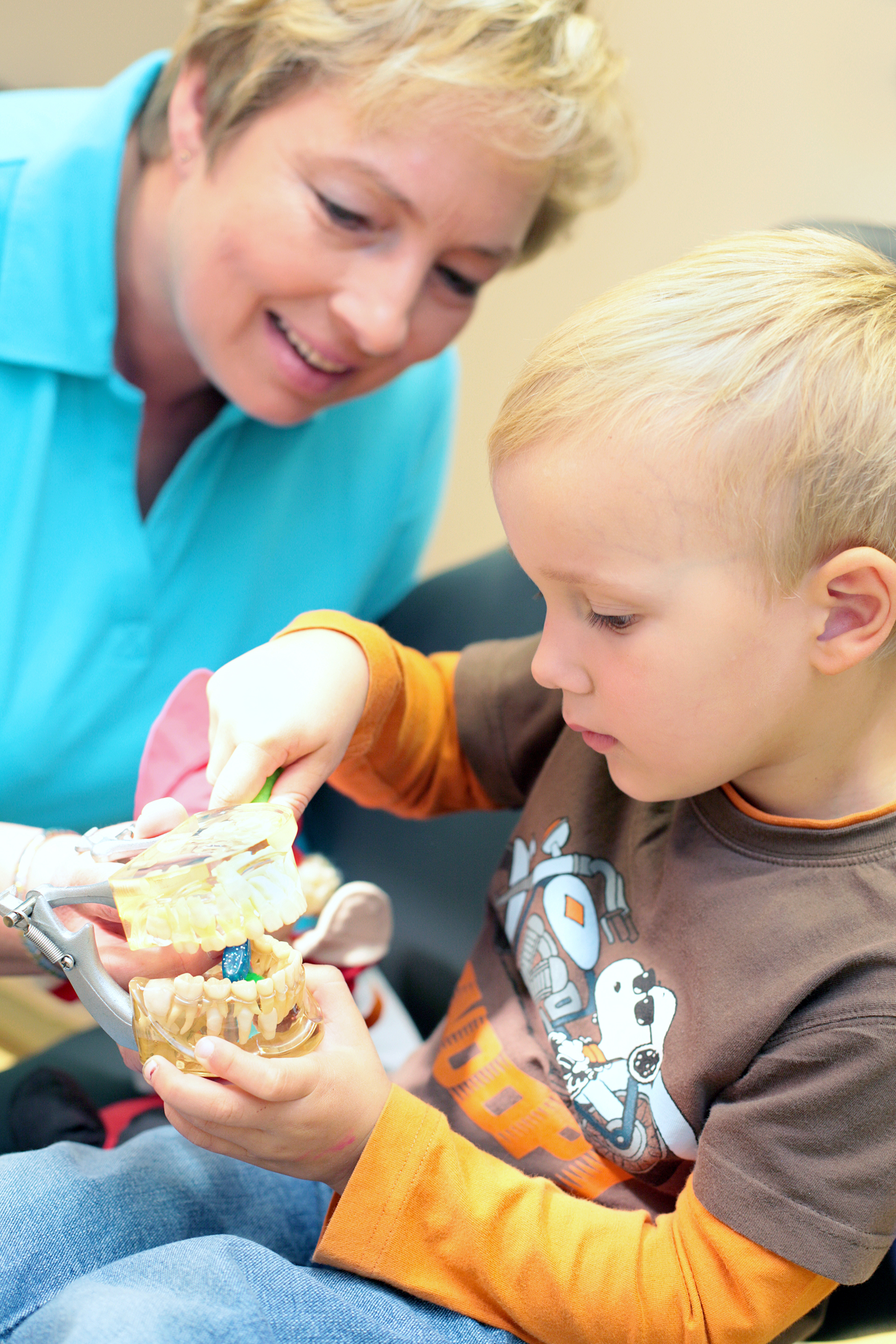 Ein Kind übt das Zähneputzen an einem Dentalmodell mit einer Zahnärztin bei Die Zahnarztpraxis Thiele & Menk in Weilburg, einer modernen Praxis, die für Patienten jeden Alters – einschließlich Kinder – persönliche Beratung und verständliche Aufklärung bietet.